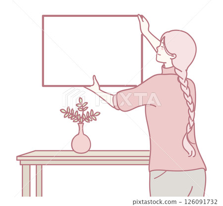 A Woman Gracefully Hanging a Picture Frame in a Warm and Cozy Living Room Environment 126091732