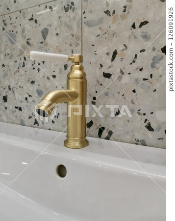 Elegant vintage-style bathroom faucet with ceramic handle and classic tile background. Perfect for interior design and plumbing concepts Elegant vintage-style bathroom faucet with ceramic handle and classic tile background. Perfect for interior design and plumbing concepts 126091926