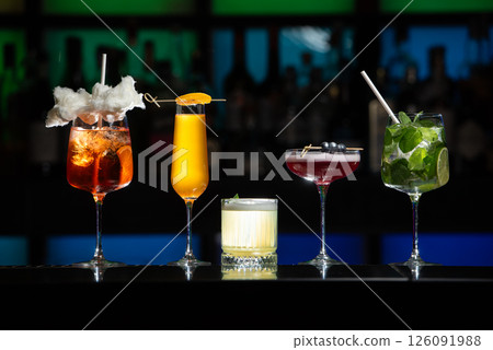 row of various colourfull alcoholic cocktails on a bar desk. Glasses of differen shapes row of various colourfull alcoholic cocktails on a bar desk. Glasses of differen shapes 126091988