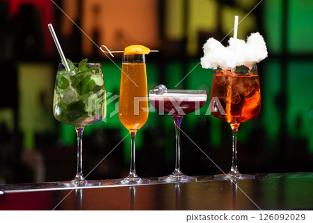 row of various colourfull alcoholic cocktails on a bar desk. Glasses of differen shapes. selective focus 126092029