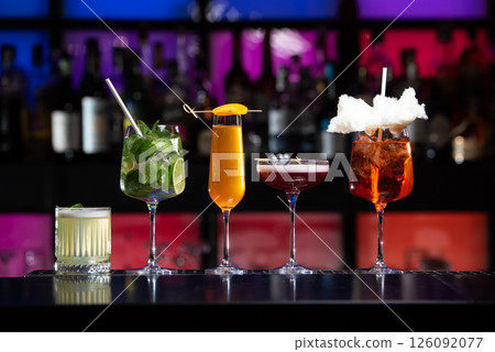 row of various colourfull alcoholic cocktails on a bar desk. Glasses of differen shapes. selective focus row of various colourfull alcoholic cocktails on a bar desk. Glasses of differen shapes. selective focus 126092077
