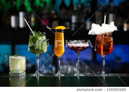 row of various colourfull alcoholic cocktails on a bar desk. Glasses of differen shapes. selective focus 126092080