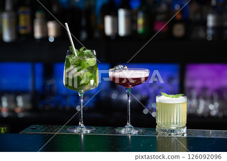 row of various colourfull alcoholic cocktails on a bar desk. Glasses of differen shapes. selective focus 126092096