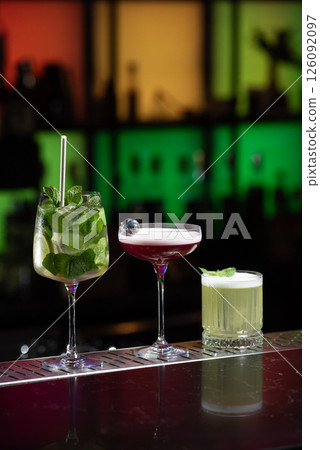 row of various colourfull alcoholic cocktails on a bar desk. Glasses of differen shapes. selective focus 126092097