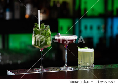 row of various colourfull alcoholic cocktails on a bar desk. Glasses of differen shapes. selective focus 126092098