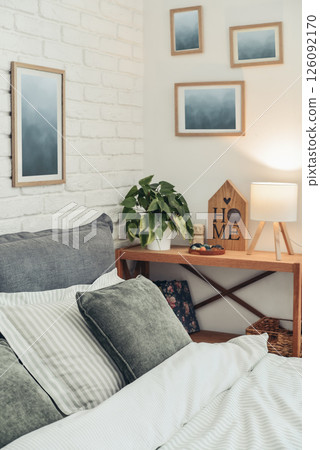 Stylish interior of bedroom with big comfortable grey bed and linen mustard plaid 126092170