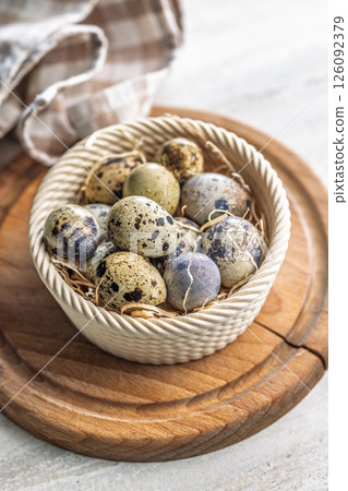 Spotted quail eggs in bowl on kitchen table. Spotted quail eggs in bowl on kitchen table. 126092379
