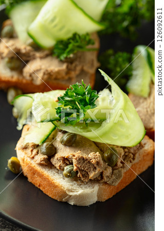 Open sandwiches with pate, fresh cucumber, capers, and parsley. Open sandwiches with pate, fresh cucumber, capers, and parsley. 126092611
