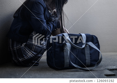 High school girl crouching on the landing of the stairs Bullying, refusal to go to school, anxiety about the future, trimmed High school girl crouching on the landing of the stairs Bullying, refusal to go to school, anxiety about the future, trimmed 126093192