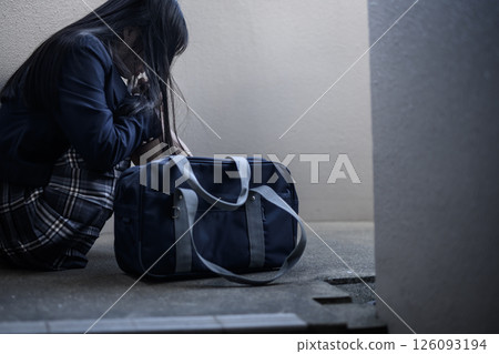 High school girl crouching on the landing of the stairs: Bullying, school refusal, anxiety about the future High school girl crouching on the landing of the stairs: Bullying, school refusal, anxiety about the future 126093194