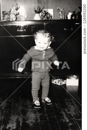 Vintage portrait of a curly little boy. The child is learning to walk. Retro photo 1967. Vintage portrait of a curly little boy. The child is learning to walk. Retro photo 1967. 126093200