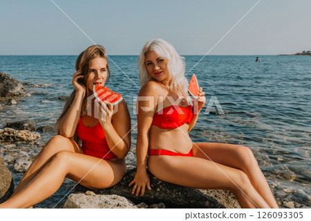 Watermelon Beach Summer: Two Women Enjoying Red Swimsuits, Seaside Relaxation, Sunny Day 126093305