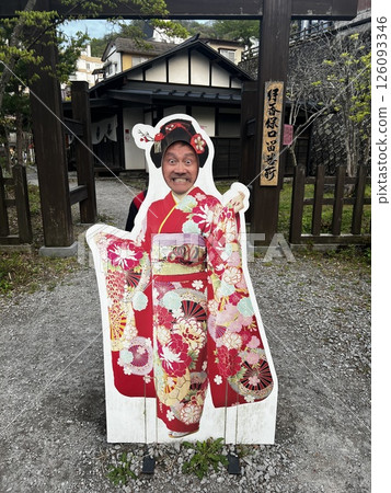 A man taking a commemorative photo in front of a kimono face-in panel 126093346