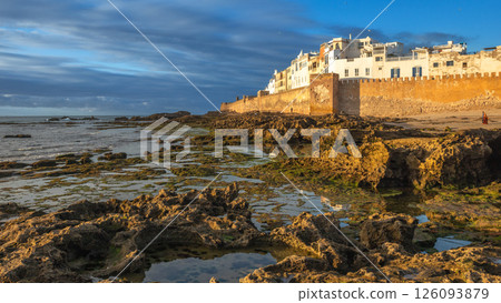 Moroccan town with low tide lakes at the walls of Skala de la Villa fortress bastion, Portuguese Mogador castle in evening time, Essaouira, Morocco 126093879