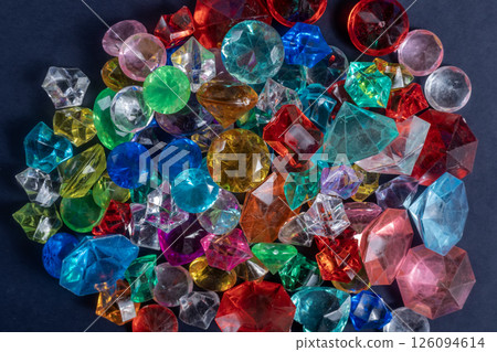 Pile of colorful assorted gemstones shimmering against a dark background. Pile of colorful assorted gemstones shimmering against a dark background. 126094614