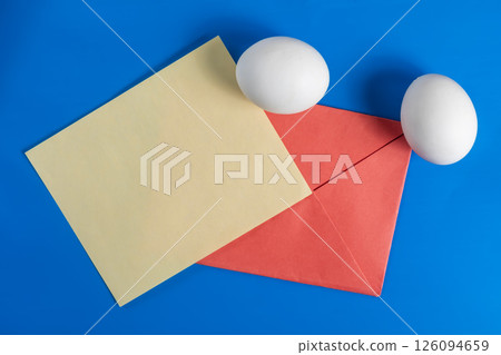 Colorful composition with white eggs, paper and envelope on a blue background. 126094659