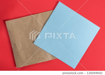Top view of an envelope with blue paper on a red background  126094692