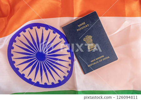 Indian passport placed over a vibrant Indian flag 126094811
