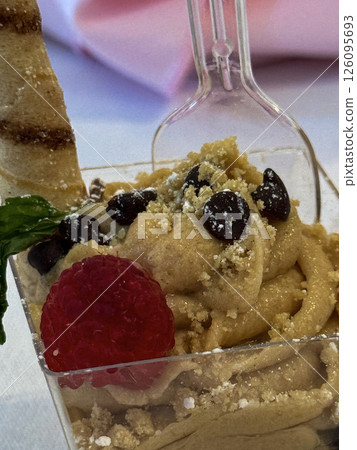 Gourmet Dessert in Clear Cup with Cookie Stick and Raspberry Garnish 126095693
