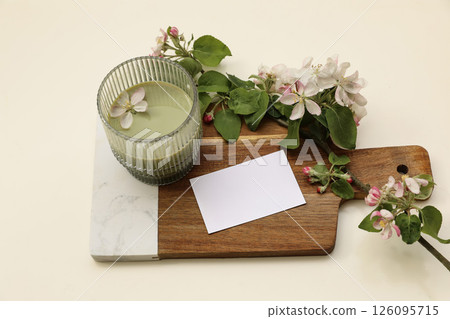 Cup of green matcha tea on wooden marble chopping board decorated with white blooming apple tree flowers branches. Blank business card invitation mockup. Branding stationery label template. Top view 126095715