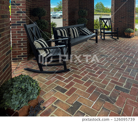 Covered Brick Porch with Black Rocking Chairs and Striped Cushions Covered Brick Porch with Black Rocking Chairs and Striped Cushions 126095739