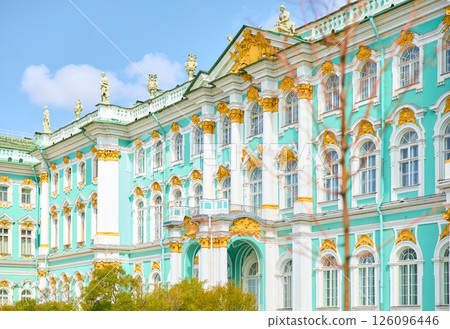 the incredibly picturesque facade of the Winter Palace through the branches of trees on a clear spring day, the heritage of Russia, the most famous landmark of St. Petersburg, the museum 126096446