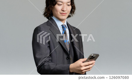 Young businessman looking at his smartphone Young businessman looking at his smartphone 126097080