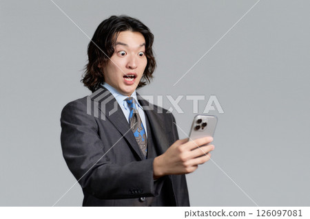 A young businessman surprised at his smartphone 126097081