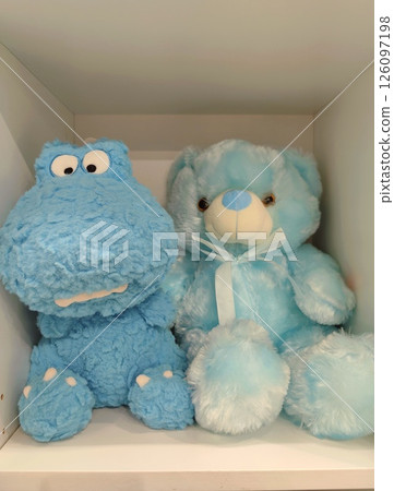 soft blue stuffed animals in cozy shelf display, creating lively and comforting atmosphere. closeup. soft blue stuffed animals in cozy shelf display, creating lively and comforting atmosphere. closeup. 126097198