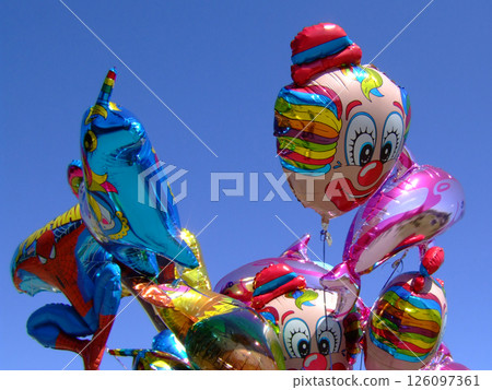 Colorful foil balloons with cartoon characters floating against a clear blue sky, creating a festive and cheerful atmosphere. High quality photo 126097361