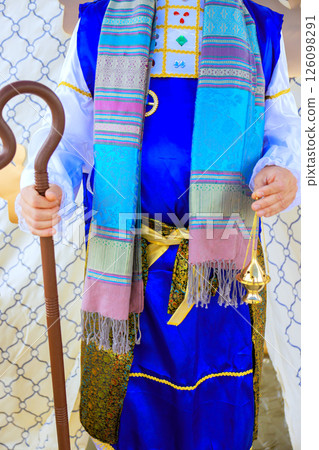 Jewish high priest dressed in traditional attire holds staff, brass incense engaged in Jew holy festivities. 126098291