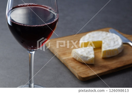 Relax with a glass of red wine and some Camembert cheese as a snack. Relax with a glass of red wine and some Camembert cheese as a snack. 126098613