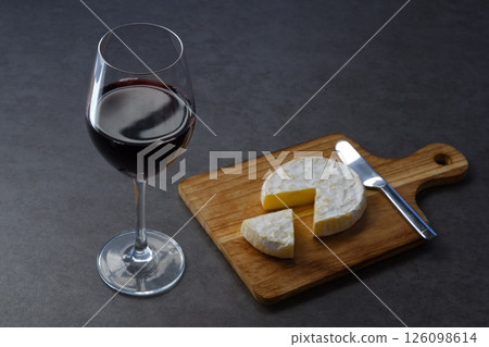 Relax with a glass of red wine and some Camembert cheese as a snack. Relax with a glass of red wine and some Camembert cheese as a snack. 126098614