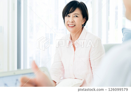 A middle-aged couple happily watching a computer in the living room 126099579