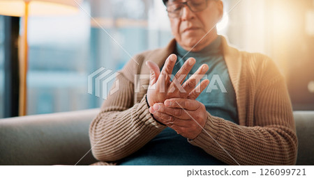 Hands, home and old man on sofa, pain and inflammation with arthritis in living room. Muscle tension, pensioner and elderly person on couch, osteoporosis and parkinson disease with fibromyalgia 126099721