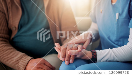 Sofa, caregiver and senior patient with holding hands for support, empathy and console for medical news. Home, nurse and old person with consultation for wellness, compassion and flare in closeup 126099738