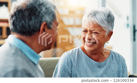 Old couple, conversation and laughing in home to relax together, marriage and commitment with communication. Senior, man and woman with talking for love, care and retirement with funny story in house 126100334