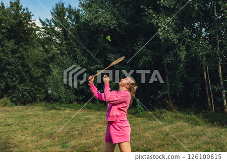 Woman play Badminton racket and shuttlecock on green grass. Outside recreation and fresh air. Healthy lifestyle nature connection sport summer activities. Stress relief hobby Woman play Badminton racket and shuttlecock on green grass. Outside recreation and fresh air. Healthy lifestyle nature connection sport summer activities. Stress relief hobby 126100815