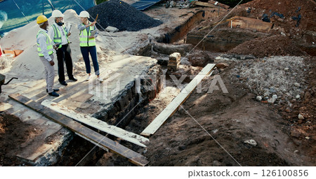 Engineering, people and meeting on construction site with tech, discussion and problem solving at foundation. Woman inspector, above team and pointing on worksite for planning with project management 126100856