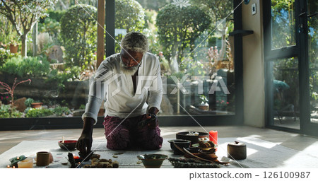 Incense, alternative medicine and mature man on floor for spiritual meditation, holistic treatment and healing. Aromatherapy, cleanse and person with stones for balance, chakra and detox for wellness 126100987