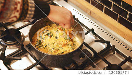 Hands, pot and cooking in home, soup and heat with ingredients, nutrition and food on stove in kitchen. Person, chef and meal prep for flavor, diet and above with vegetables, recipe and stir at house 126101774