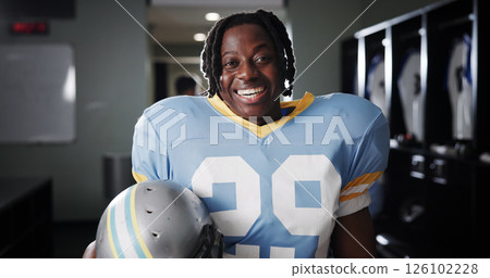 Black man, American football player and excited for portrait in locker room, pride and ready for sports. Person, professional athlete and smile with confidence, career and helmet at club in USA Black man, American football player and excited for portrait in locker room, pride and ready for sports. Person, professional athlete and smile with confidence, career and helmet at club in USA 126102228
