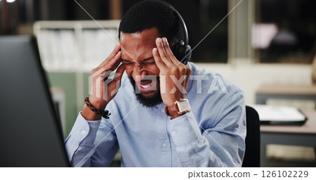 Black man, call center and computer with stress at night, headache or pain with communication or telecom mistake. Frustrated, upset and male agent with help desk pressure, working late and migraine 126102229