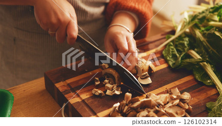 Hands, mushroom and cutting board with cooking in home, meal prep and knife with spinach for healthy food. Person, chef and kitchen for organic produce, nutrition and diet for wellness at apartment 126102314