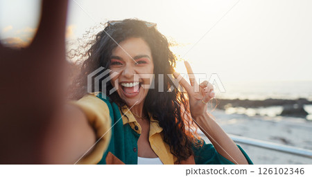 Beach, selfie and woman with peace sign, vacation and travel with profile picture, social media and ocean. Portrait, person and seaside with live streaming, tropical island or influencer with holiday 126102346