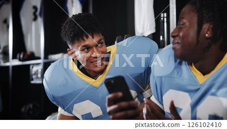 Football, phone and friends or men in locker room for rookie drafting, pro league research and contact. Game score update, team roster with people for connection, training schedule and player stats 126102410