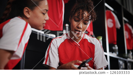 Online, team and girls with smartphone, gym and conversation for match on website, watching and sports. Locker room, friends and people with mobile for streaming, talking and preparing for game Online, team and girls with smartphone, gym and conversation for match on website, watching and sports. Locker room, friends and people with mobile for streaming, talking and preparing for game 126103333