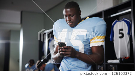Football, phone and reading with man in locker room for rookie drafting, pro league research and contact. Game score update, team roster with person for connection, training schedule and player stats Football, phone and reading with man in locker room for rookie drafting, pro league research and contact. Game score update, team roster with person for connection, training schedule and player stats 126103372