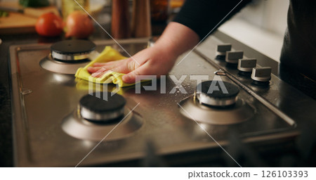 Hand, cleaning stove and man with cloth, hygiene and routine with dirt, home and remove bacteria. Closeup, person and chef in kitchen, wiping and disinfection with responsibility and prevent virus 126103393