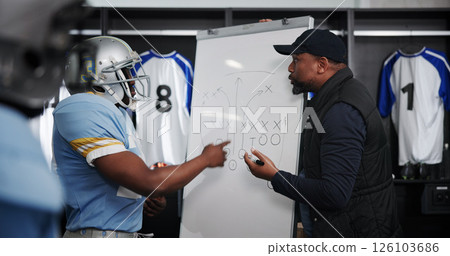 Board, writing and football with coach and team in locker room for game plan, sports strategy or defense formation. Touchdown tactics, match feedback and discussion with people and training advice Board, writing and football with coach and team in locker room for game plan, sports strategy or defense formation. Touchdown tactics, match feedback and discussion with people and training advice 126103686